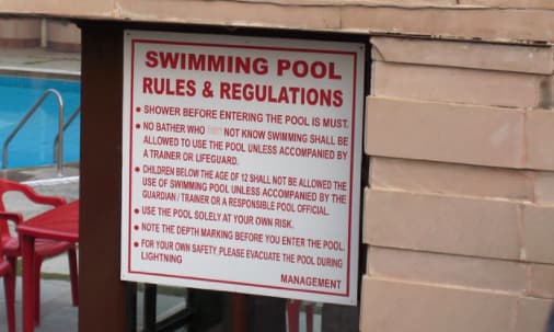 在白色背景上用粗体红色文字标出“游泳池规则和规定”。